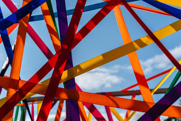 Framework of multi-colored ribbons against the blue sky close-up