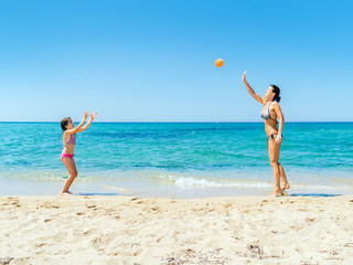 mutter spielt mit tochter ball am strand