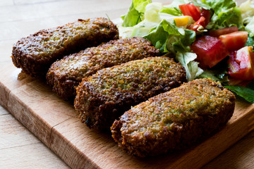 Falafel with Salad on wooden surface.