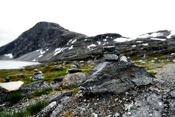 Hiking stones in focus with snow covered mountains and a lake in the unsharp  background in norway