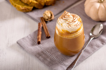 Pumpkin spice latte, hot coffee drink with pumpkins, whipped cream and spices