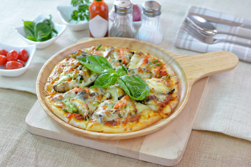 Homemade vegetable pizza on wooden plate cutting board style