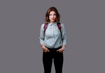 Female with leather backpack isolated on grey background.