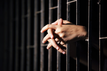 Obraz premium hands of prisoner in jail as background.