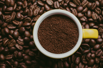 Coffee powder in ceramic cup on coffee seeds surface. 