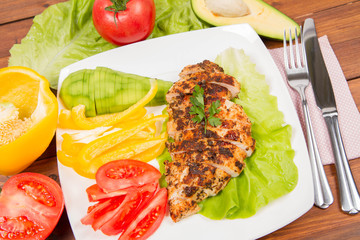 Chicken fillets with vegetable on the side (avocado, tomato, bell pepper)