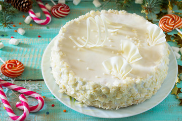 Holiday cake with icing white chocolate on festive christmas background.
