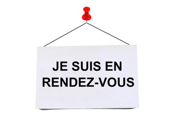 Je suis en rendez-vous écrit sur un carton punaisé 