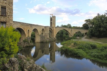 Fototapeta na wymiar bridge and a tower over a river and its reflection, Spain