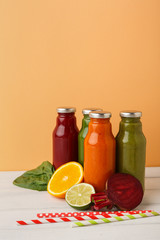 Assortment of detox smoothies in glass bottles on wall background.