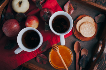 Hot tea with apples and honey on a tray. Autumn harvest