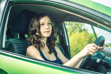 Woman in the car. Hands on the wheel. Focused and tense. Lesson in driving school.