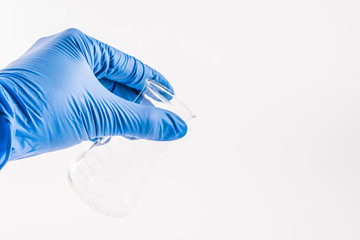 hand of scientist hold empty chemical laboratory beaker. Research science and medical laboratory.