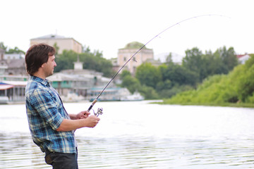 A man with a beard is fishing in the river