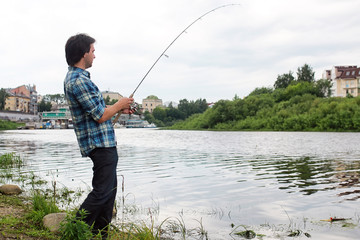A man with a beard is fishing in the river