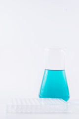 research, science and clinic background. 96 well micro plate and  laboratory beakers with colorful...