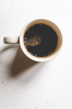 Black coffee in mug with bubbles