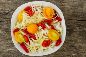 Fresh vegetable salad on rustic wooden table