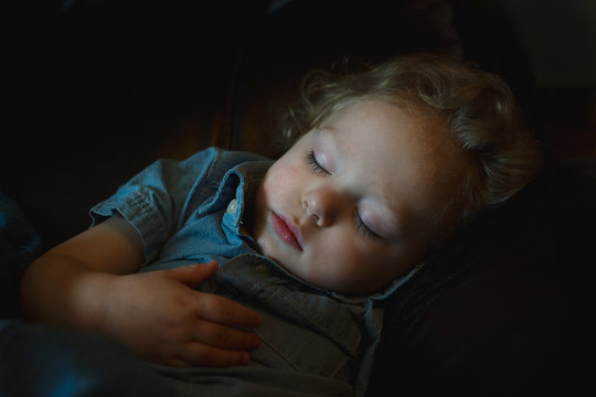 young boy sleeping on couch