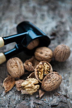 Walnuts and nutcracker on wooden background