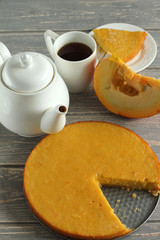 Pumpkin pie on grey wooden desk.