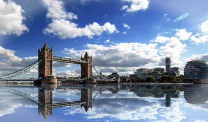 Obraz premium Tower Bridge spanning the River Thames with a dramatic blue cloudy sky and good water reflection