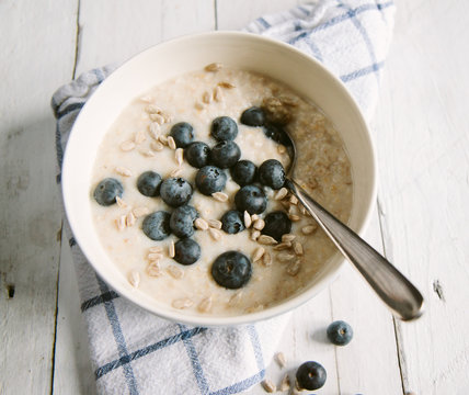 A bowl of porridge with blueberries and sunflower seeds