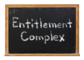 Fototapeta premium Entitlement Complex written in white chalk on a black chalkboard isolated on white