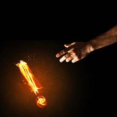 Concept of attention or punctuation with burning exclamation mark on dark background