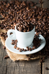 Fototapeta premium A white set of coffee on wooden and sacking background with cinnamon and coffee beans