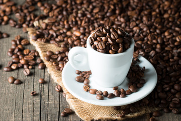 A white set of coffee on wooden and sacking background with cinnamon and coffee beans