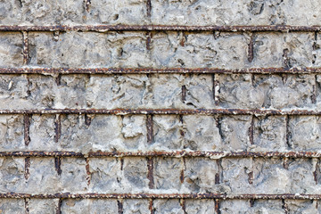 Fragment of a gray concrete wall with metal structures