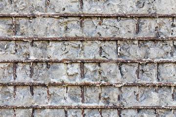 Fragment of a gray concrete wall with metal structures