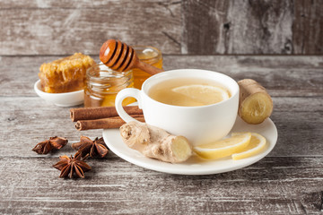 A glass cup of green natural tea with ginger, lemon, mint and honey on wooden rustic background. Healthy drink.