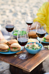      Hands Friends toasting red wine glass and having fun outdoors.