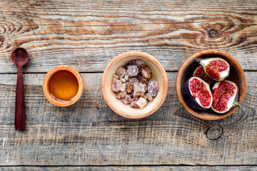 Make jam. Fresh blue figs in bowl, sugar and honey on wooden background top view