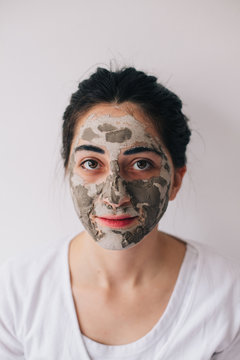 Portrait of a beautiful brunette woman with cosmetic facial mask