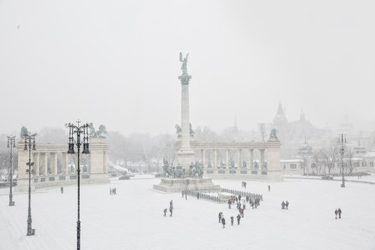 Heroes' Square completely covered with snow in the Winter with unrecognisable people