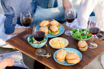      Hands Friends toasting red wine glass and having fun outdoors.