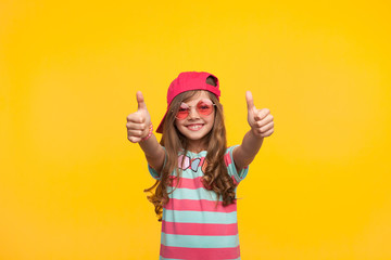 Stylish little girl showing thumbs up