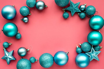 Christmas toys frame. Blue balls and stars on pink background top view