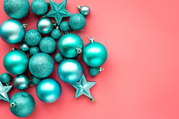 Christmas toys. Blue balls and stars on pink background top view copyspace