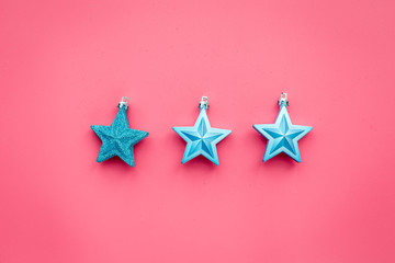 Christmas toys pattern. Blue stars on pink background top view copyspace