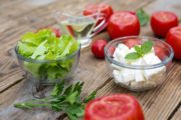 Ingedients for healthy salad consisting of lettuce, tomatoes and cheese