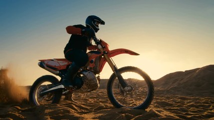 Following Shot of the Professional Motocross Driver Riding on His FMX Motorcycle on the Extreme Off-Road Terrain Track. Shot on RED EPIC-W 8K Helium Cinema Camera.