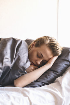 Close-up of sick young woman sleeping in bed