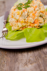 Vegetable salad (potato, carrot, corn, pea, egg, leek) with mayonnaise eaten with a fork