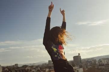 Redhead girl dancing and laughing on the rooftop