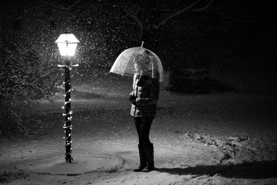 Young woman standing by a lamp post
