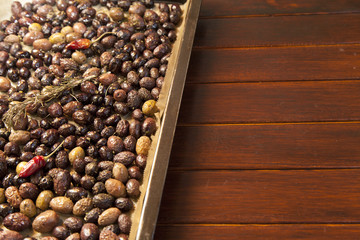 Baking fresh, colorful, organic olives, with rosemary, red hot peppers and mediterranean herbs, close-up, selective focus, space for text